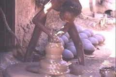 Village potter - the heavy wheel is stirred with a stick