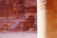 The Treasury, Petra, immense sandstone column with resting figure in arab head dress. A camel is couched on the ground beyond