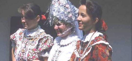 Hungarian women in traditional dress, with lots of frills and high headdress