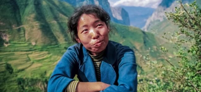 A wry smile for the 'television people' from a woman at the roadside in forested mountains in china